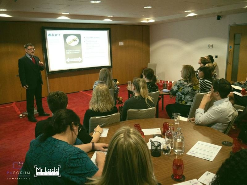 An IAM speaker presenting professional development pathways to a conference audience