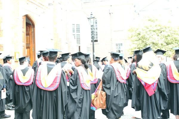IAM graduates in gowns and mortarboards gathered outside on graduation day