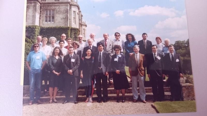 Colour archive photograph of an international group of IAM members on the steps of a country house