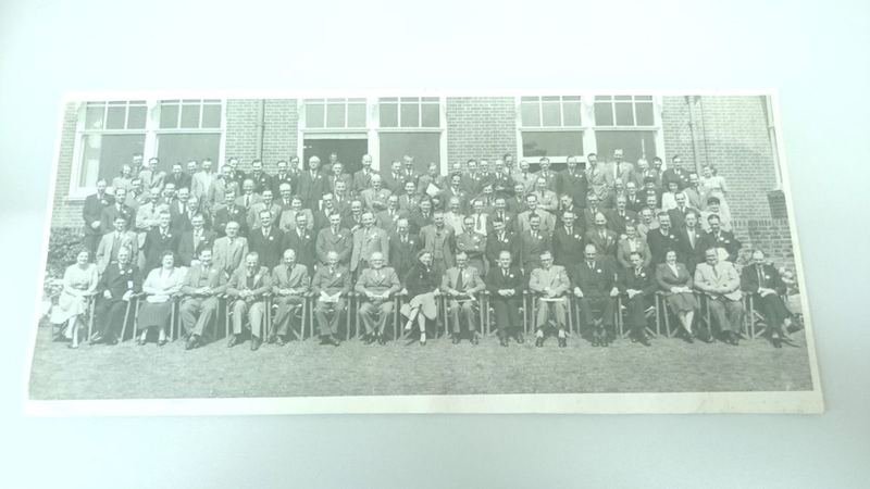Archive group photograph of a large OMA conference assembled outside a brick building