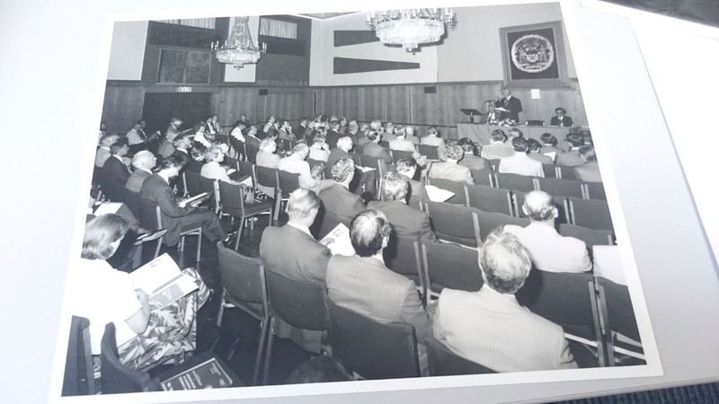 Archive photograph of a large conference audience beneath chandeliers and the Institute’s arms
